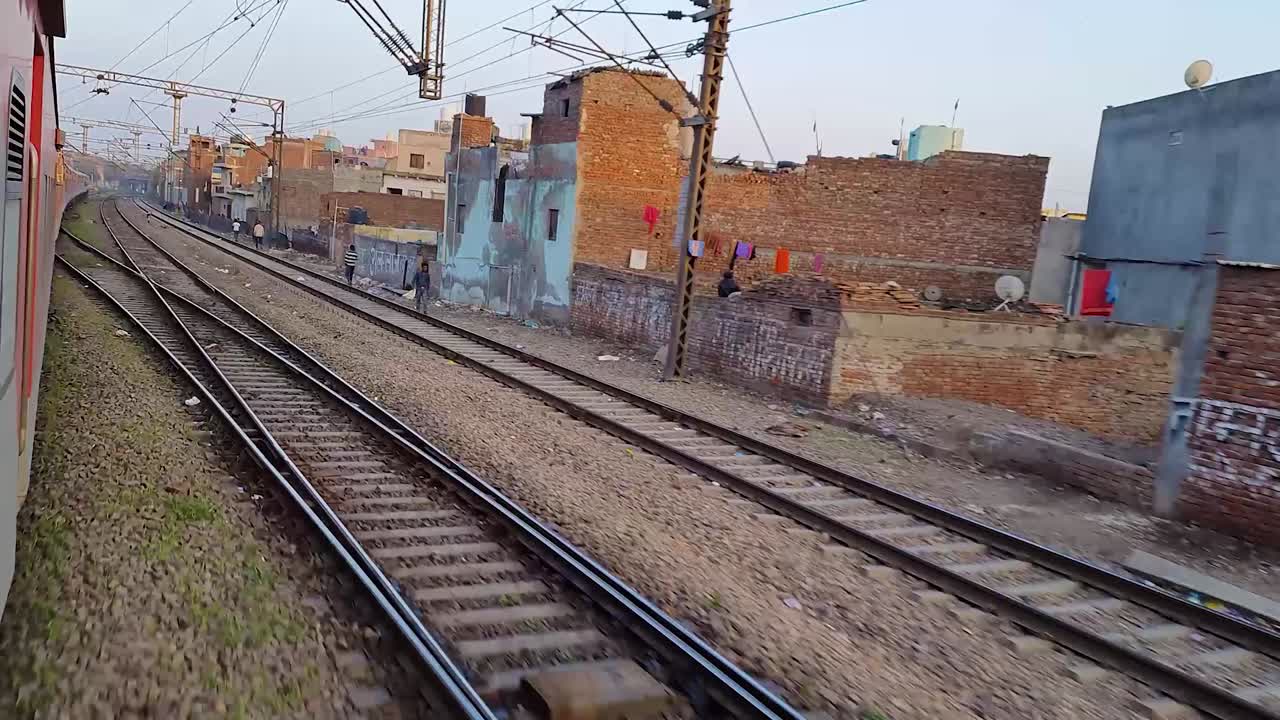 Trem de passageiros circulando nos trilhos atravessando a cidade pela manhã. O vídeo foi gravado na estação ferroviária de Nova Déli em 04 de agosto de 2022.