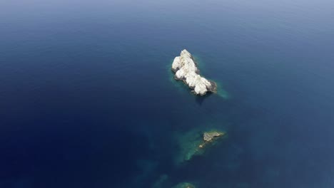 en un mar de azul una roca emerge del agua