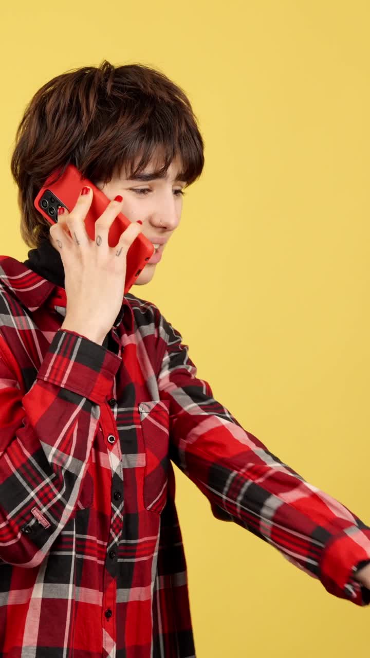 Young person on a phone call against a yellow background