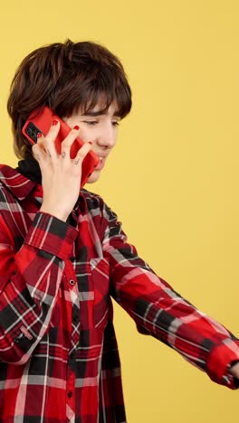 young person on a phone call against a yellow background
