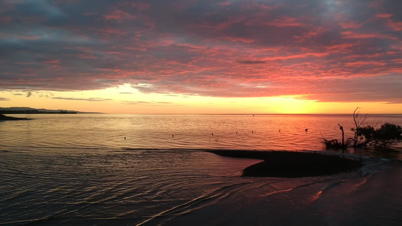 Beautiful sunrise with stunning red sky over the ocean, low clouds in the morning create a dramatic start to the day