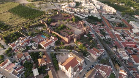 rising aerial over the church and castle in silves, portugal