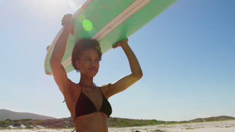 female surfer carrying surfboard on her head 4k