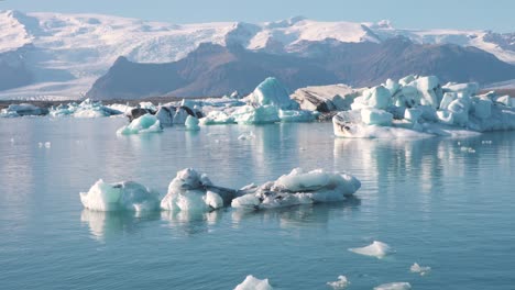 laguna marina fría en el océano ártico con icebergs y montañas más allá