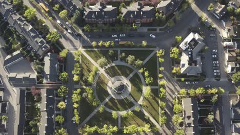 Aerial-sunrise-birds-view-Gazebo-town-square-whereby-school-buses-pickup-students-headed-to-school-and-holding-up-traffic-overlooking-a-replica-manmade-community-square-sun-is-rising-EastNorth-SQR1-5