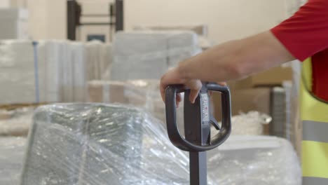 warehouse worker pushes hand cart out of frame, 4k