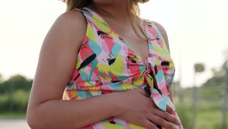 una chica embarazada camina con un hermoso vestido y sombrero