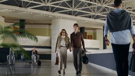 business couple walking through airport lobby