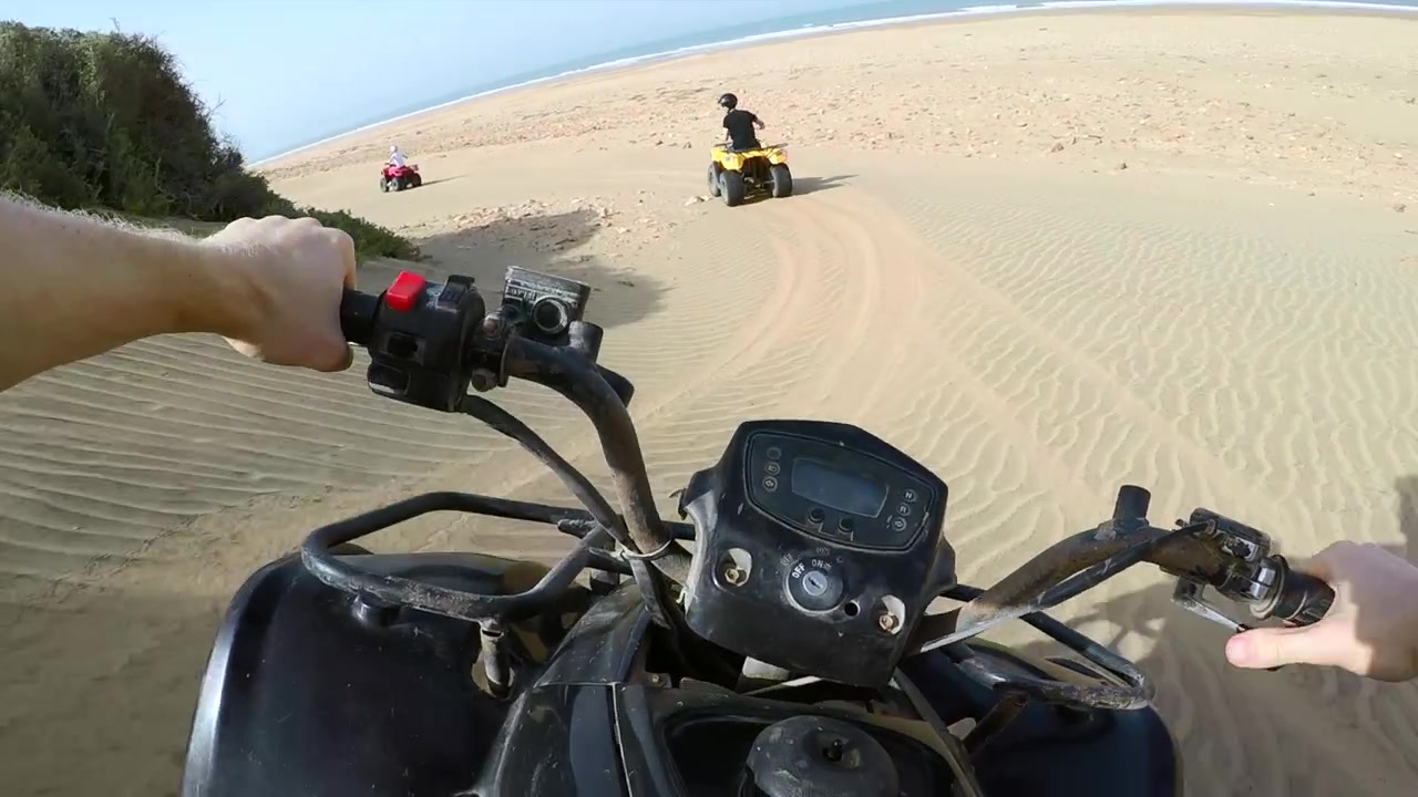 POV di un quad che sale sulle dune di sabbia sulla spiaggia in Marocco.