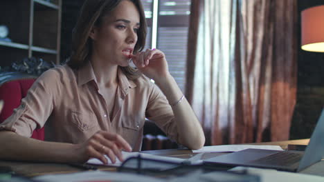 Focused-business-woman-working-on-laptop-computer-in-home-office