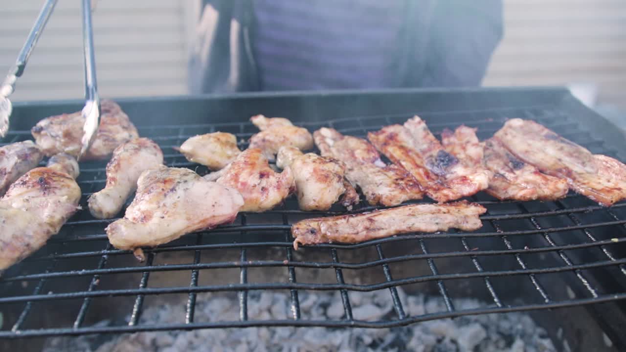 Meat being cooked and turned on a barbecue