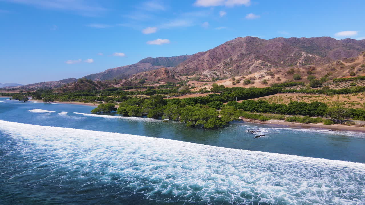 Aerial Landscape Of Mountain And Valley In Front Of Ocean Water In Nusa Tenggara, Indonesia. panning shot
