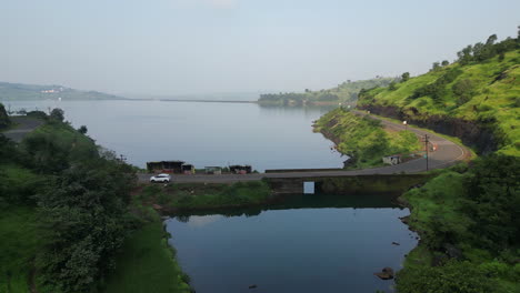 aerial top view of road through green woods and blue lake nashik maharashtra 4k drone