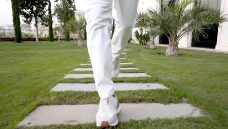 Detail-of-man-legs-with-sport-clothes-running-on-pavement-with-grass