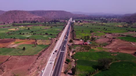 crop fields land with hill mountains and national highway 34 at siluwa ghati, ramanpur, hulki, madhya pradesh, india. day time, push in, moving down, drone shot, 4k.