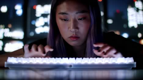 engaged in digital creation: a focused individual typing intently on a backlit keyboard against a nighttime cityscape