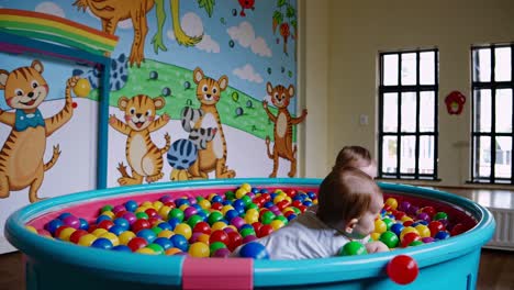 twin babies playing in a ball pit