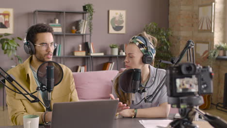 la cámara está grabando a una mujer y un hombre sentados en la mesa mientras hacen un podcast 1