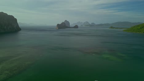 Hilly-islands-and-turquoise-sea-water-in-the-Philippines,-wide-aerial