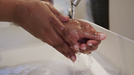 close up african american plus size woman washing hands in bathroom, slow motion