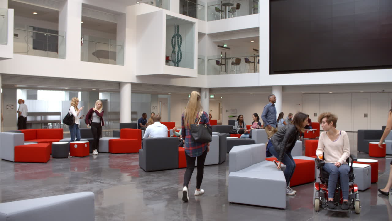 Studerende i lobbyens mødeområde på et moderne universitet