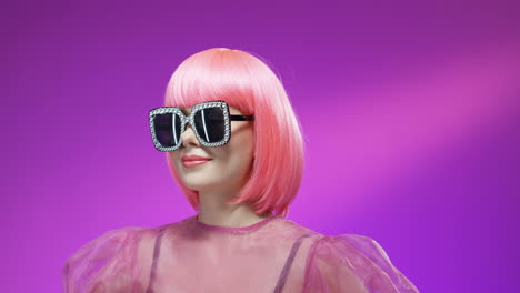 portrait of beautiful woman wearing a pink wig and glamorous glasses