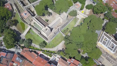 Aerial-view-of-a-midieval-castle-surrounded-with-trees-in-the-city-of-Lisbon,-Portugal