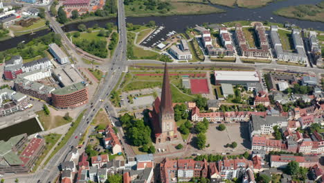 Tilt-down-aerial-shot-of-Saint-Peters-church.-Old-and-famous-religious-building-with-tall-and-pointed-spire.-Traffic-on-multi-lane-road-leading-around