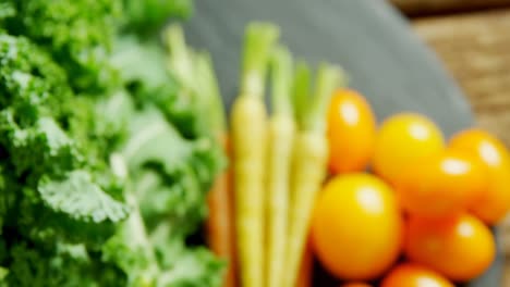 légumes à feuilles avec des carottes et des tomates sur une table en bois 4k