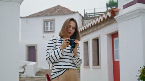 girl making travel pictures walking old town. vertical tourist exploring city