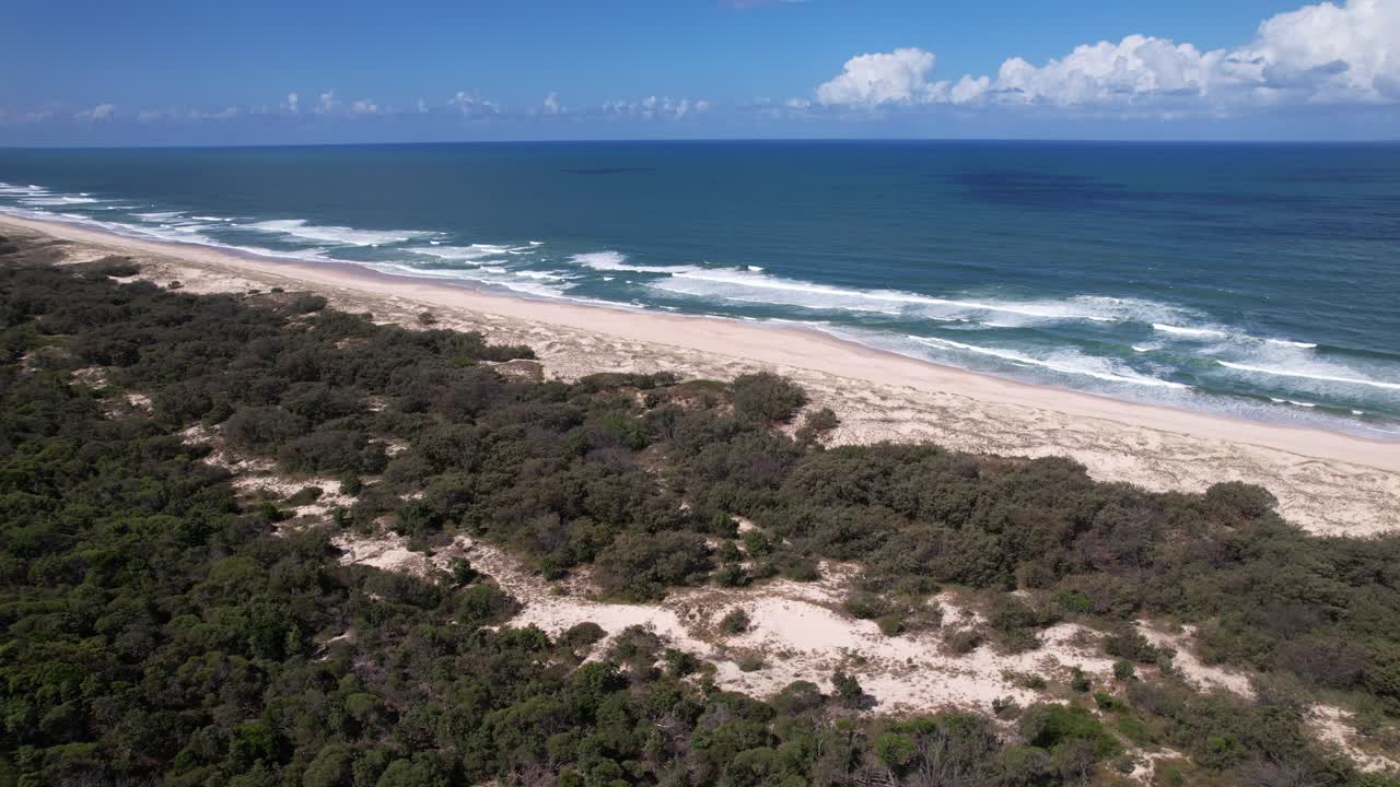 Pristine Beach On South Stradbroke Island With Rolling Waves And Coastal Scrub Along Shoreline. Queensland, Australia. wide aerial shot