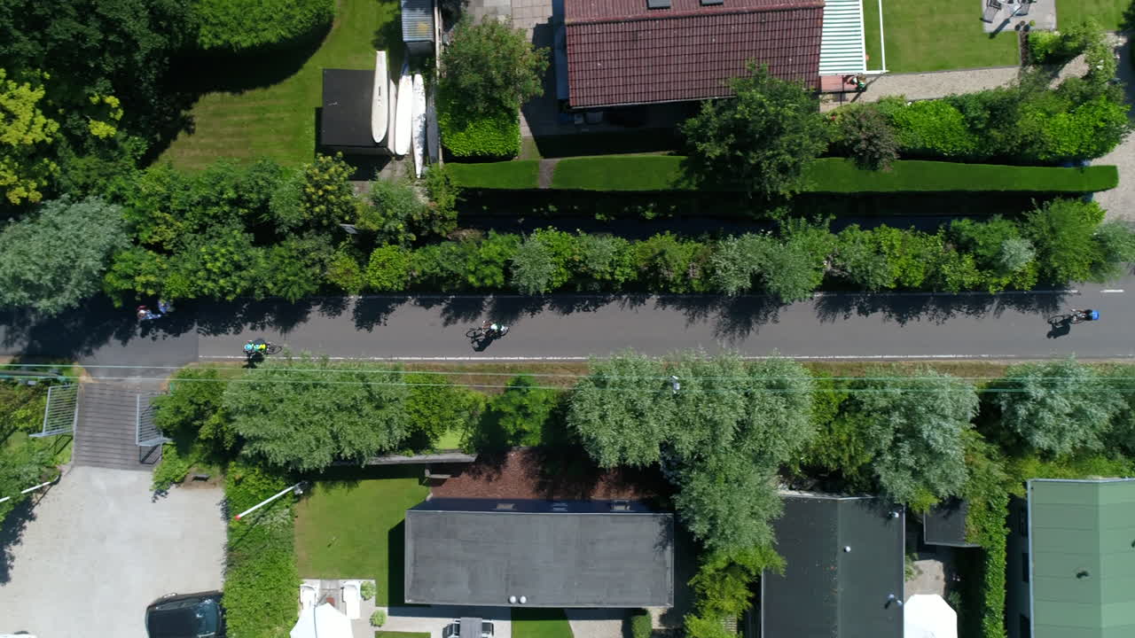 네덜란드의 reeuwijkse plassen 근처 마을의 집을 따라 도로에서 자전거를 타는 자전거 타는 사람들의 공중 전망
