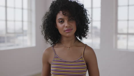 independent-mixed-race-woman-portrait-of-beautiful-hispanic-girl-looking-serious-confident-at-camera-afro-hairstyle-in-apartment-windows-background