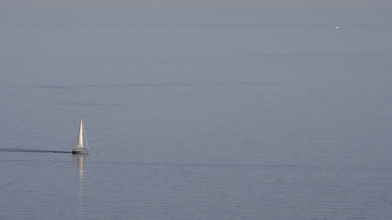 маленькая синяя яхта на морской поверхности