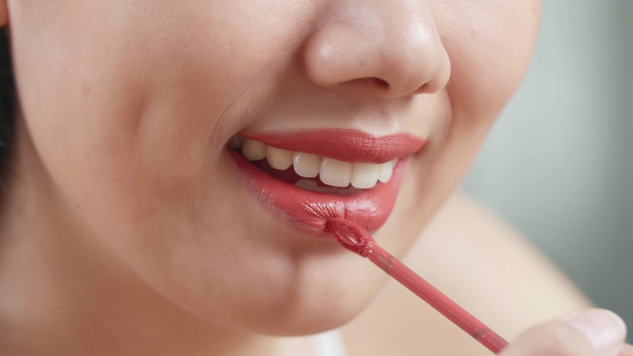 mujer aplicar lápiz labial rojo