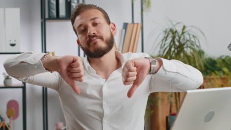 upset businessman showing thumbs down dislike bad work disapproval dissatisfied feedback at office