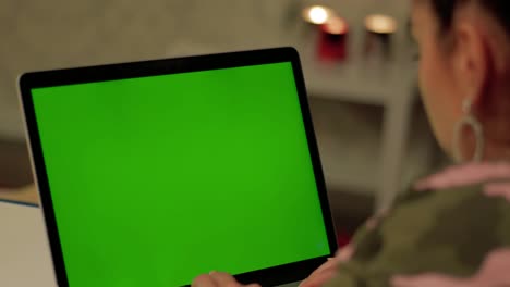 girl in camouflage clothes works on laptop with green screen