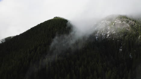 Timelapse-De-Nubes-Que-Se-Forman-Alrededor-Del-Pico-De-La-Montaña-Con-Densos-Pinos-En-El-Bosque