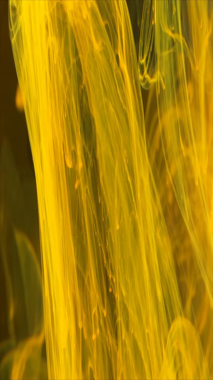 Inchiostro Giallo Vivace che si Agita e si Diffonde in Acqua Scura