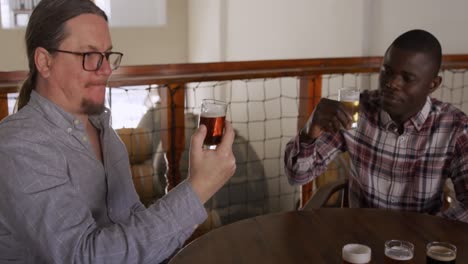 hombre caucásico y afroamericano probando cervezas en un pub de una microcervecería