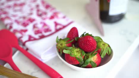 Pan-over-red-silicone-spoons-and-fresh-picked-strawberries-making-a-special-valentine's-day-cake-vegan-chocolate-cake-eggless-plant-based-dairy-free