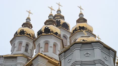 the golden domes of the holy myrrh-bearing women church in kharkiv show shrapnel damage, evidence of the shelling of ukraine's cultural sites and civilian areas during the ongoing conflict
