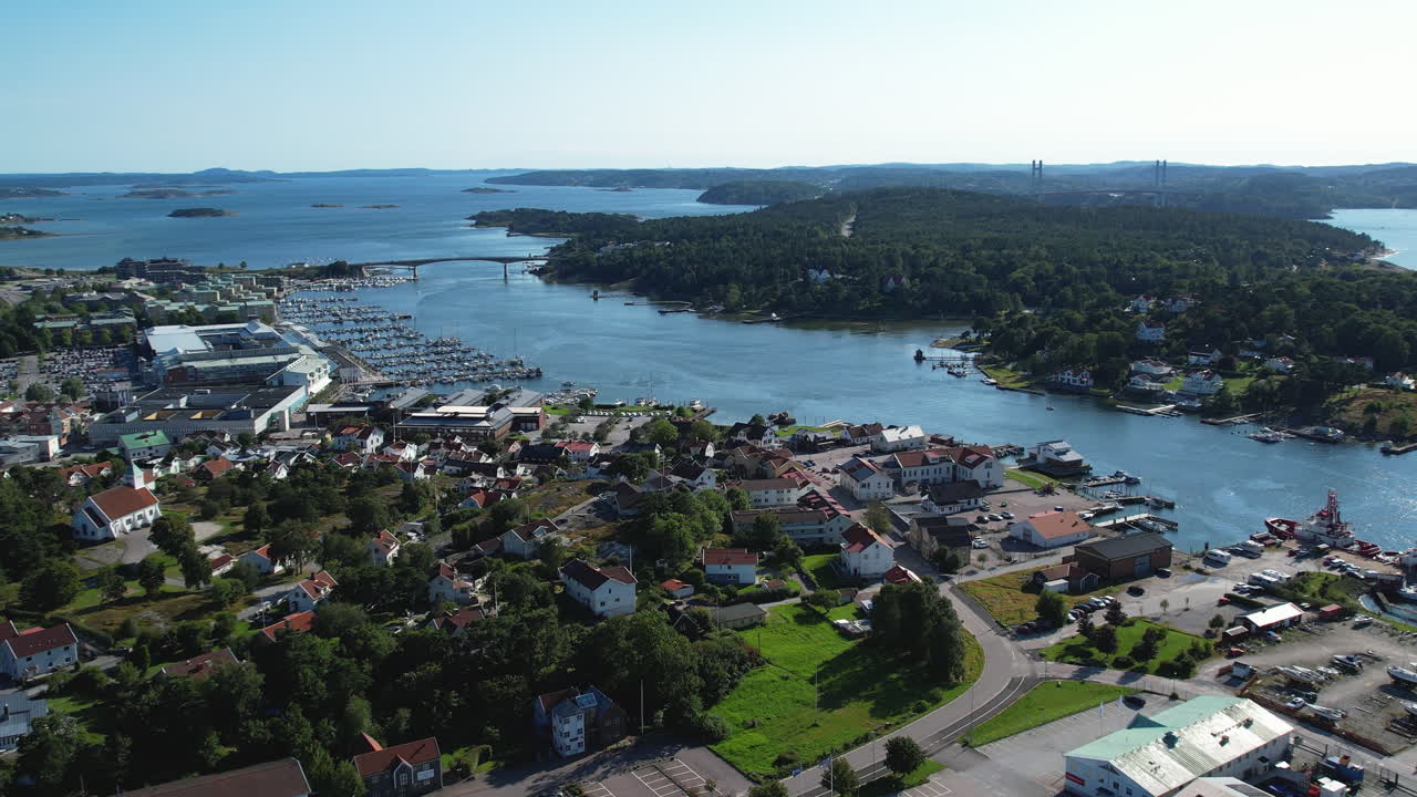 Aerial drone shot of Stenungsund harbor with boats, bridge and blue water in the day in Bohuslan, Sweden