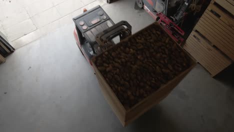 farmer driving into potato storage with forklift transporting crate filled birds eye view