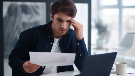 hombre de negocios enfocado leyendo documentos. hombre serio chequeando datos en papeles.