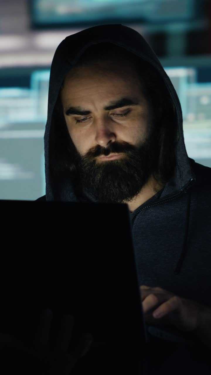 Vertical Video Male hacker operates in stealth mode breaching system access through coding