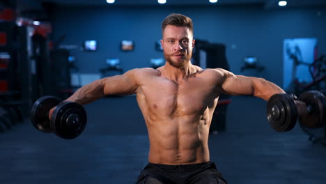fit young man lifting dumbbells doing workout at a gym. sport, fitness, weightlifting, bodybuilding, training, athlete, workout exercises concept. slow motion.