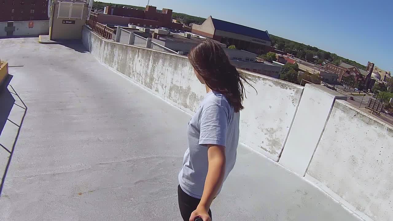 Ung kvinne som kjører skateboard ned et parkeringshus