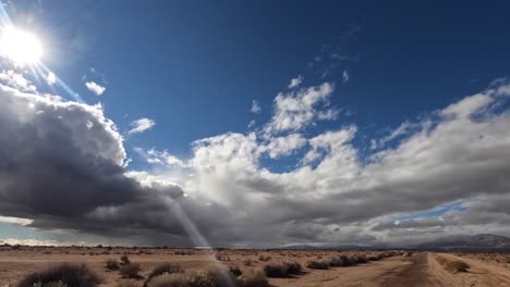 nuvole di pioggia tempestosa sopra l'arido paesaggio del deserto del mojave con le montagne in lontananza - lasso di tempo