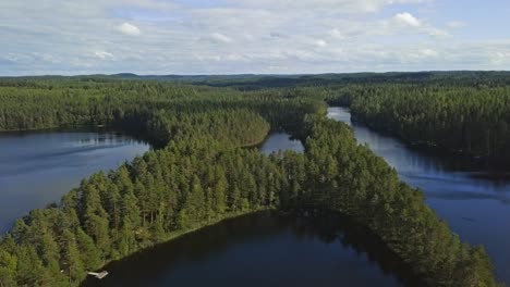 Imágenes-Aéreas-De-Un-Lago-Finlandés-En-Verano,-Cielo-Azul,-Nubes-Pesadas-Y-Sol,-Isla-En-Forma-De-X